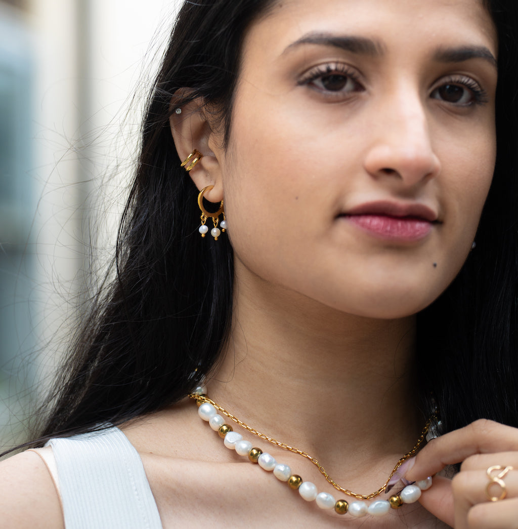 small semi hoop earrings in gold featuring a freshwater pearl drop down design