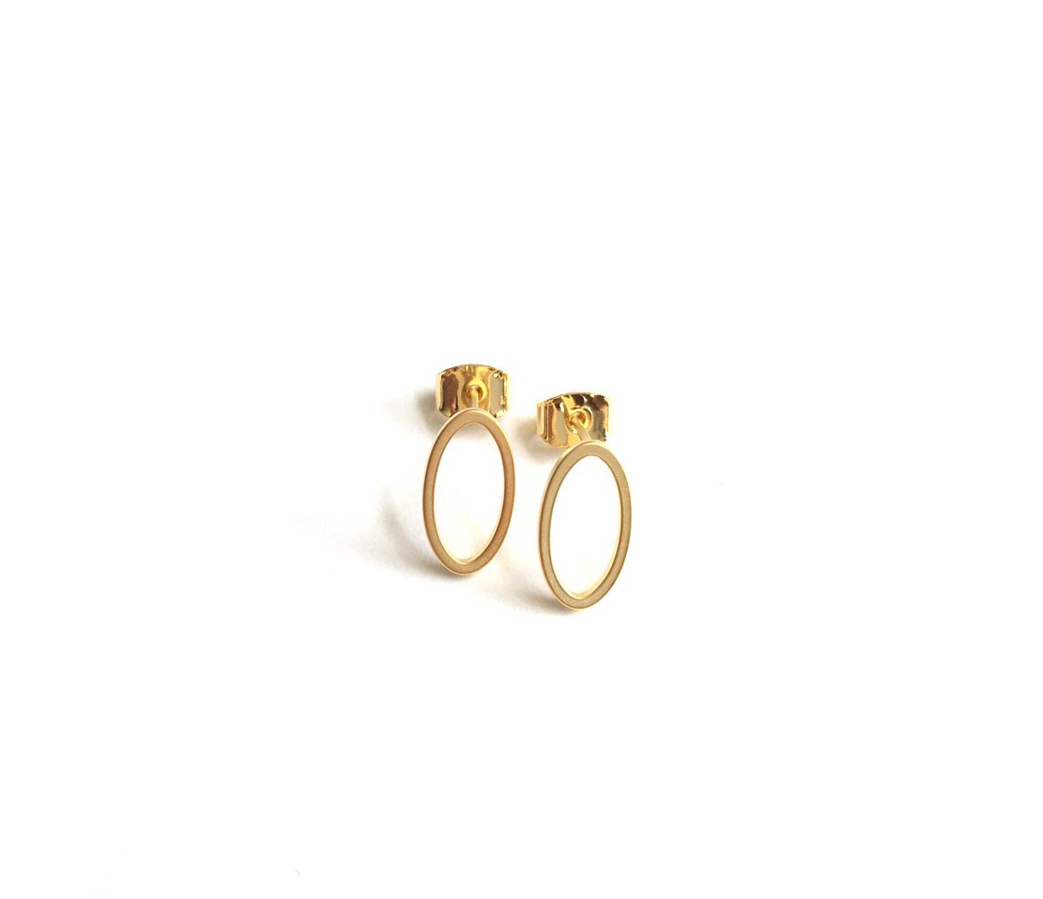 small and minimalist oval shaped stud earrings with a gold finish